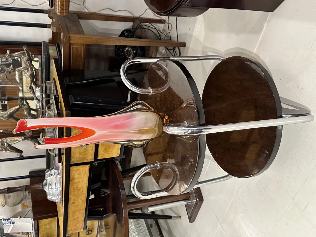 Vaso di Murano con tonalità rosa e forma stilizzata, circondato da antichità.