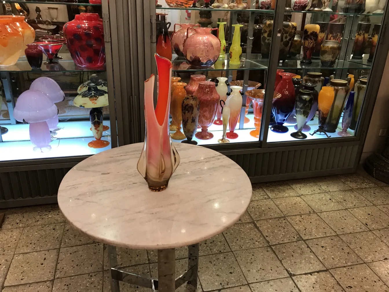 古董穆拉诺花瓶放在圆桌上，背景有其它花瓶