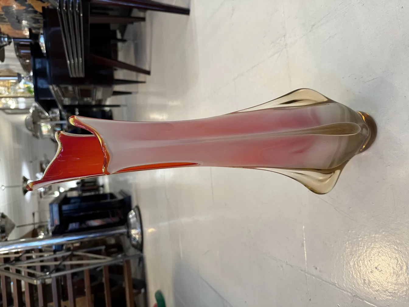 florero de murano con tonalidades rojas y doradas, elegante diseño con bordes ondulados, ambientado en espacio clásico