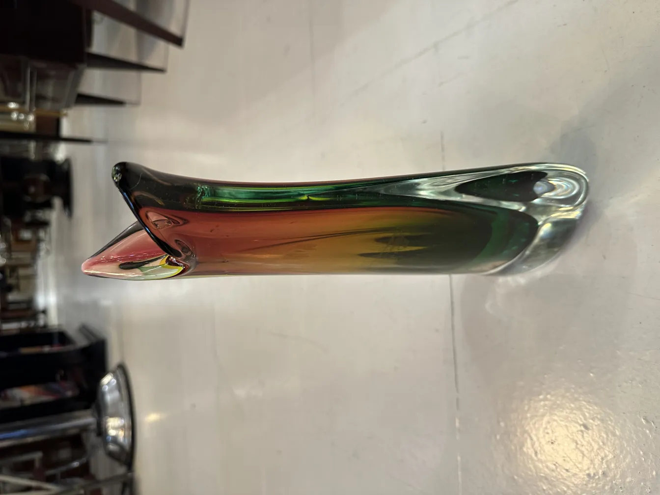 vaso di murano antico con design curvo e colori vivaci, in un negozio