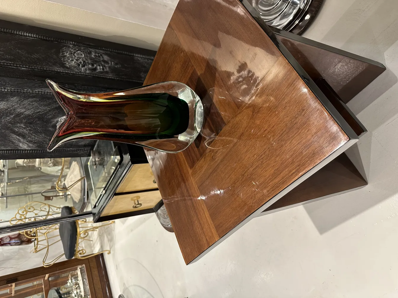 antik murano vase mit gewellten Formen und lebhaften Farben, neben einem Holztisch
