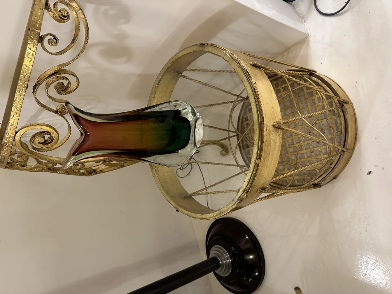 antique murano vase with stylized shape and colors white, green, and amber, on a golden table