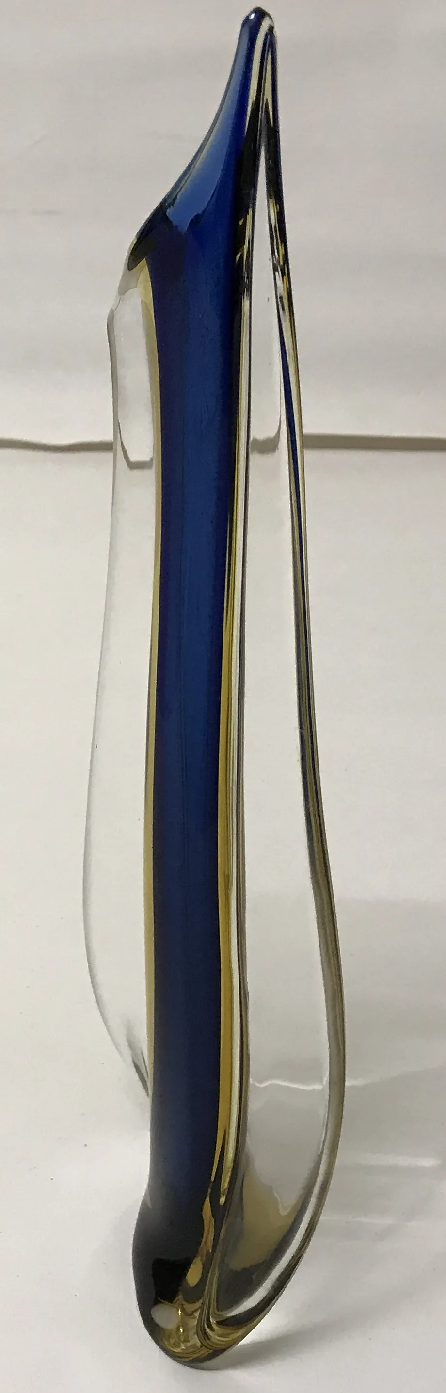 Vaso di Murano con design ondulato in blu e trasparente su sfondo neutro.