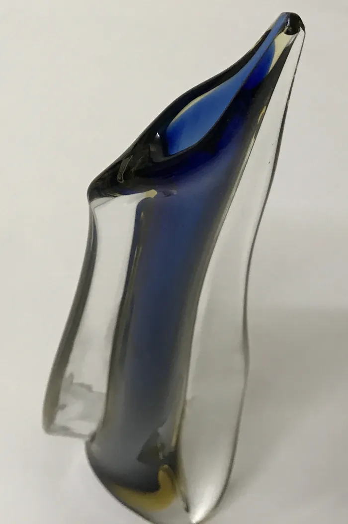 vase murano avec des formes ondulées et des couleurs bleues sur un fond blanc.