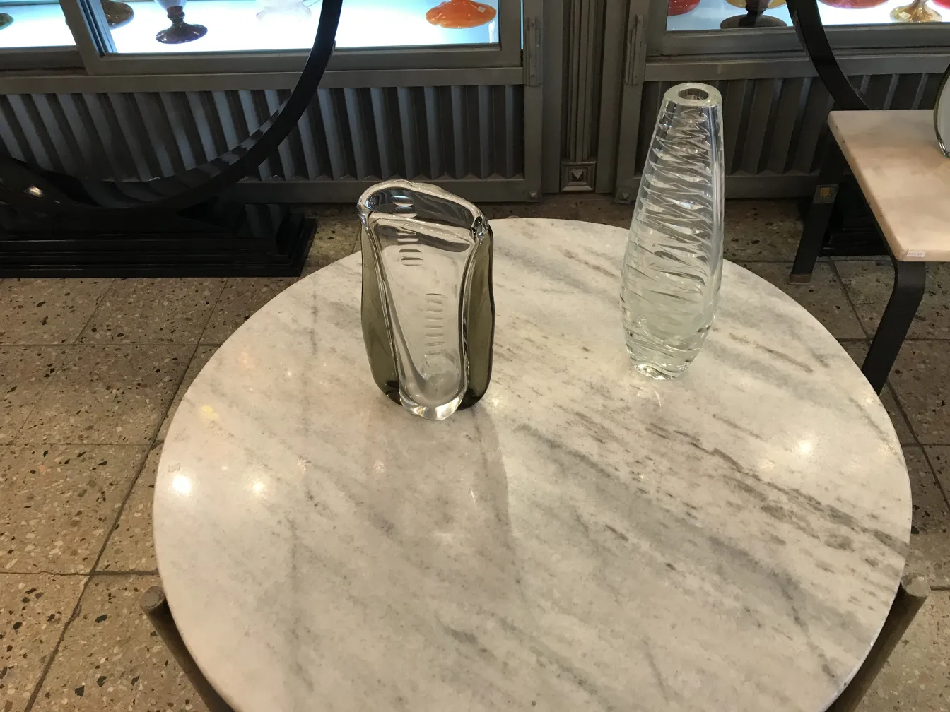 florero de murano con diseño curvado en una mesa de mármol