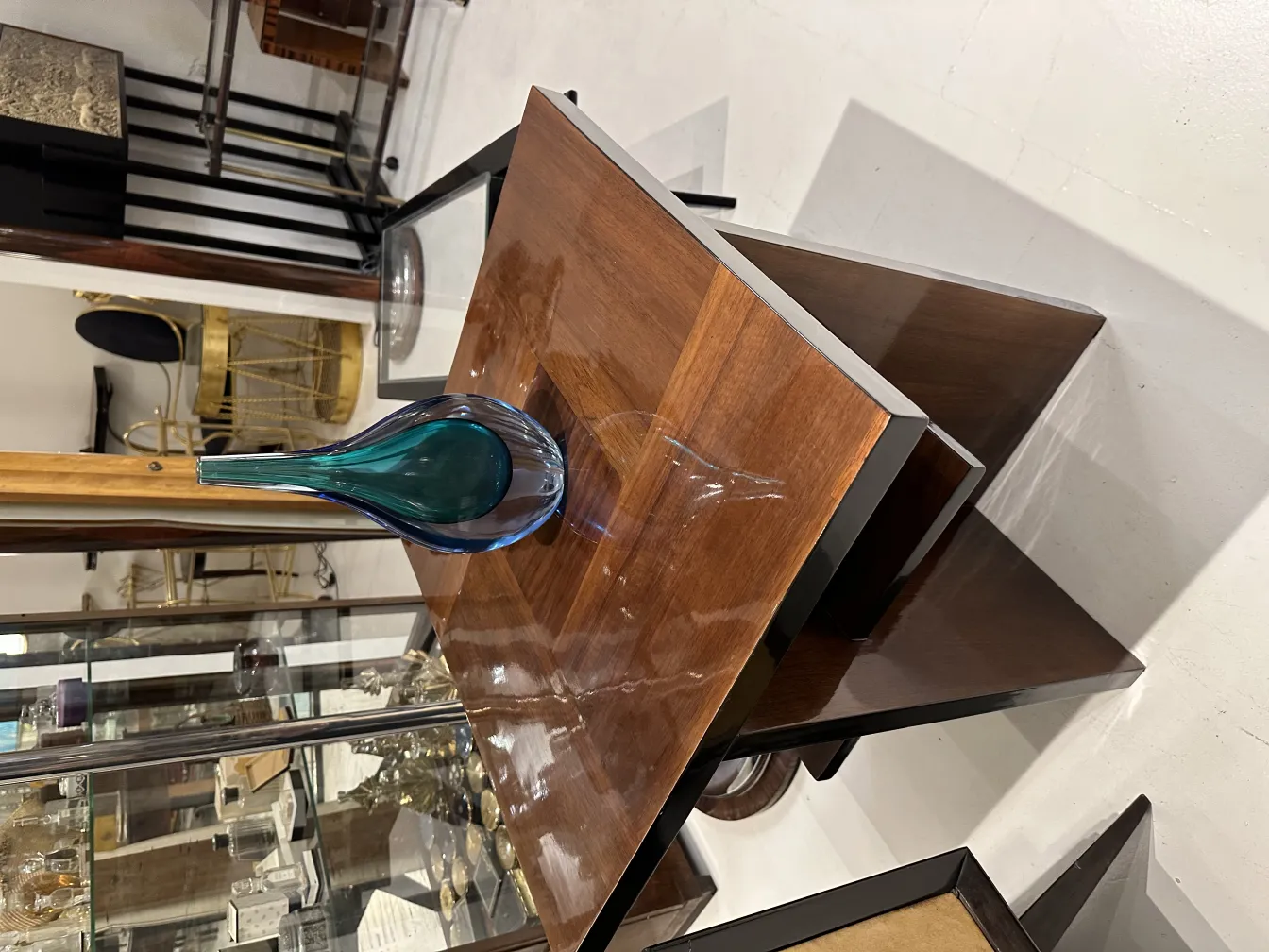 florero antiguo de murano sobre mesa de madera, con fondo de antigüedades