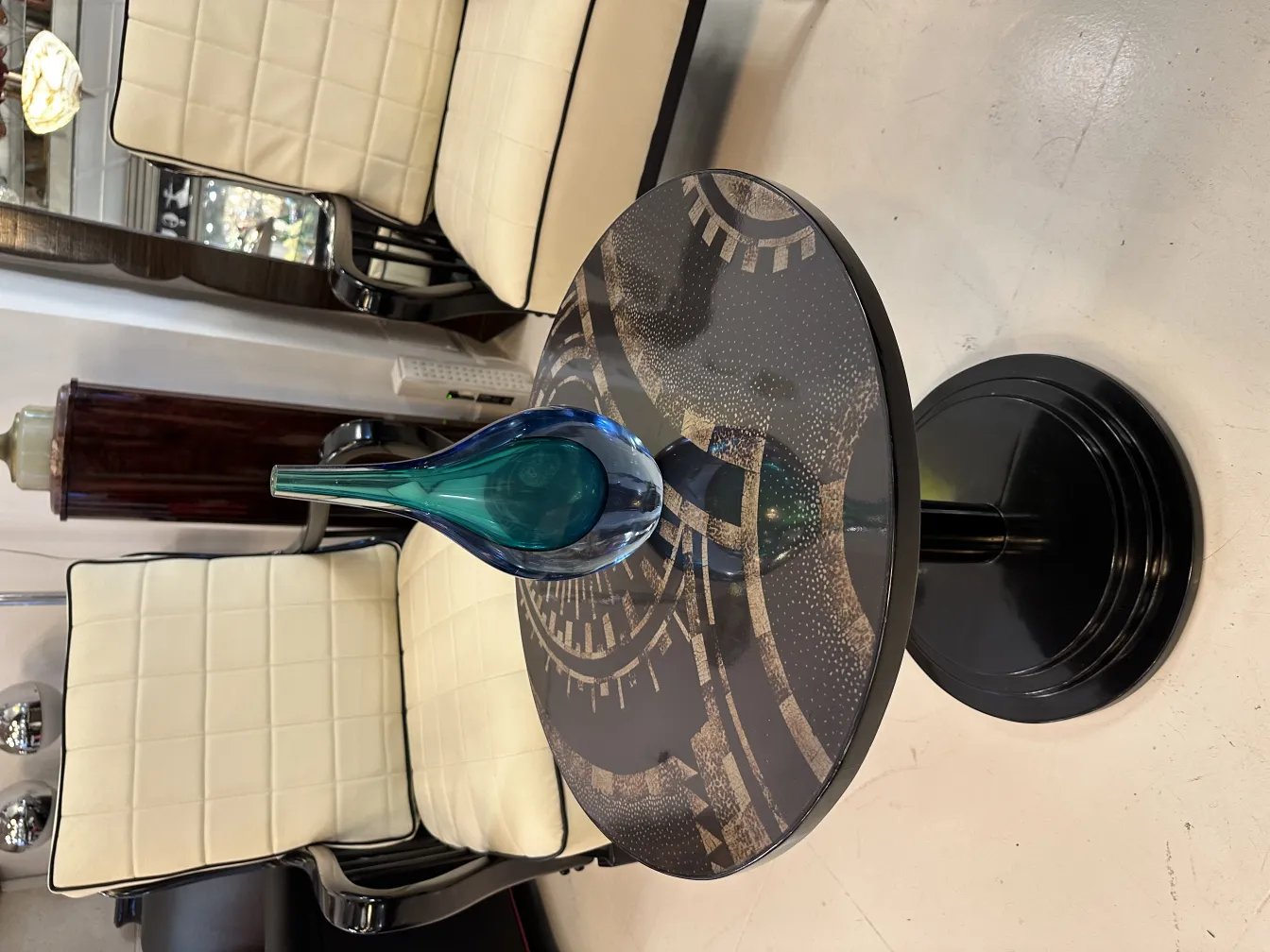 vaso di murano su un tavolo con sedie bianche