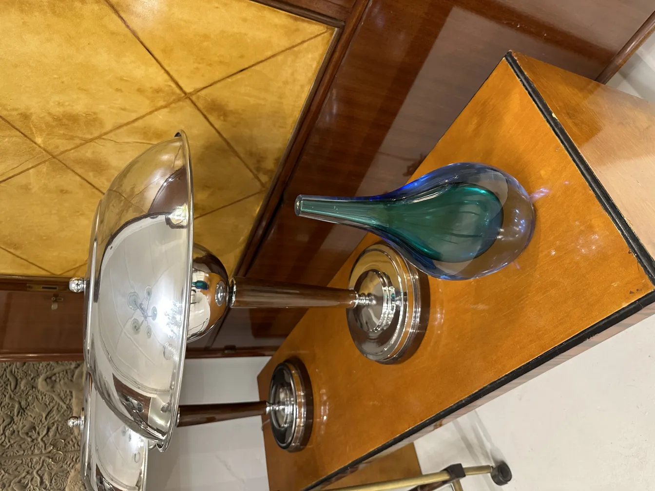 مزهرية مورانو قديمة زرقاء وخضراء في بيئة أنيقة.