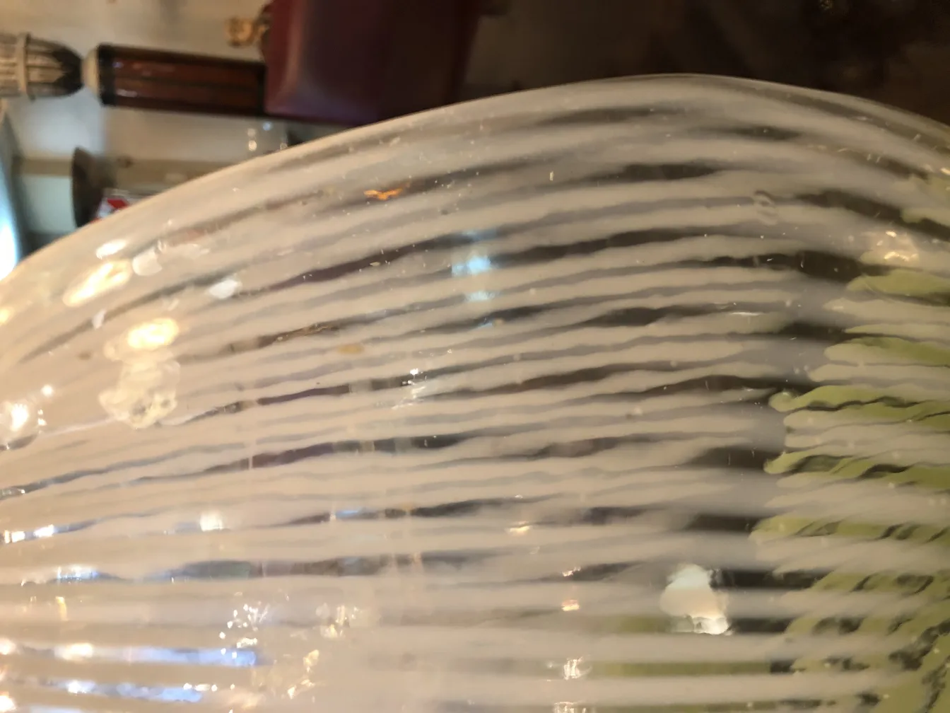 vaso de murano com decorações brancas e verdes em um ambiente clássico