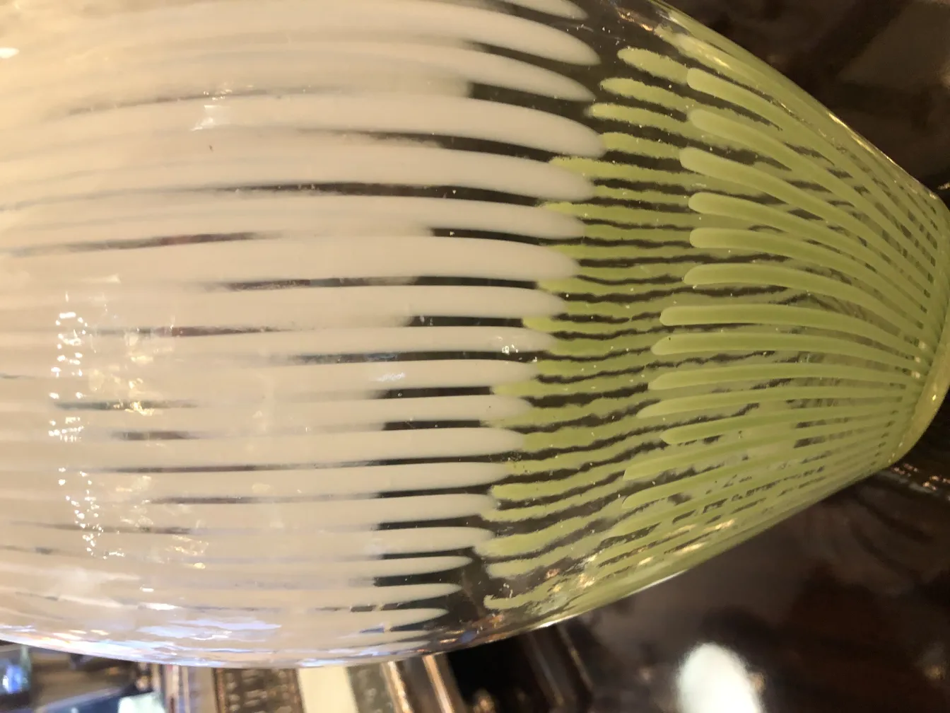 Antike Murano-Glasvase mit grünen und weißen Mustern, dunkler Hintergrund.