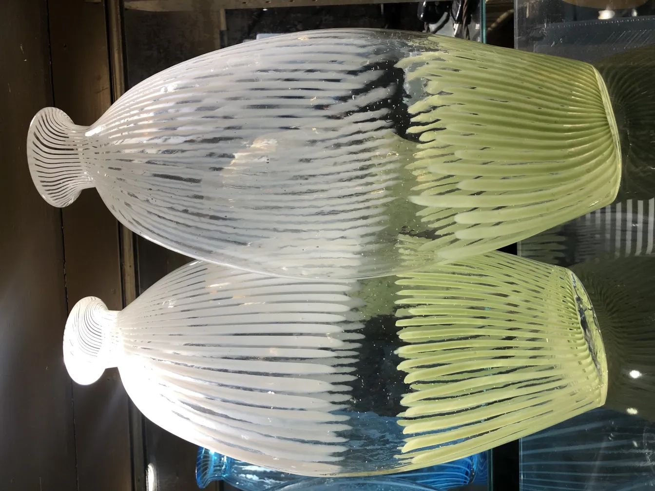 vase murano ancien, design de lignes ondulées et douces, couleur verte et blanche, dans un cadre élégant