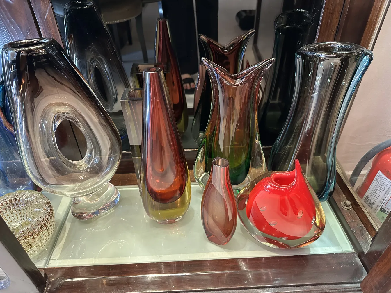 vaso antico di Murano in varie forme e colori vivaci, accanto ad altri vasi