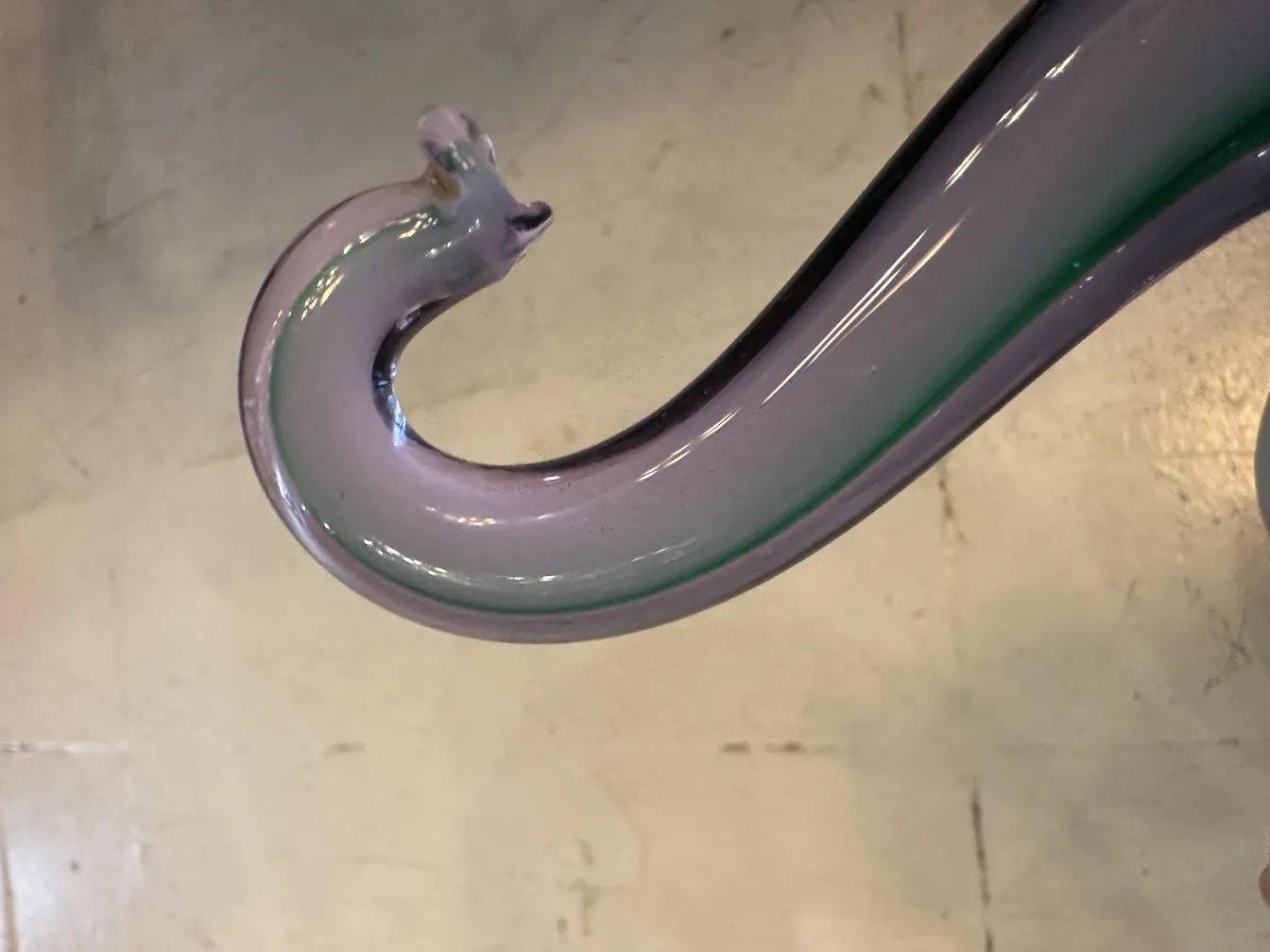 Detalhes em tons de roxo e verde de uma escultura de Murano antiga em um ambiente elegante.