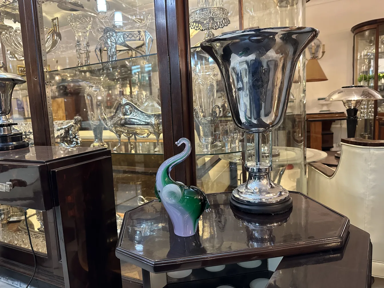 Escultura de Murano con formas curvas y colores vibrantes, sobre mesa de madera