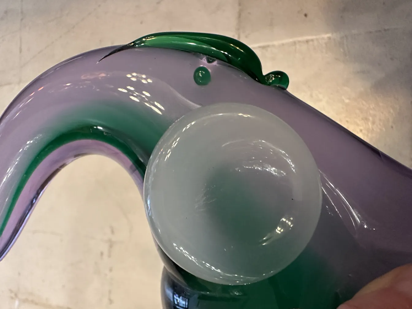 Murano sculpture with vibrant colors and flowing shapes in a lit environment