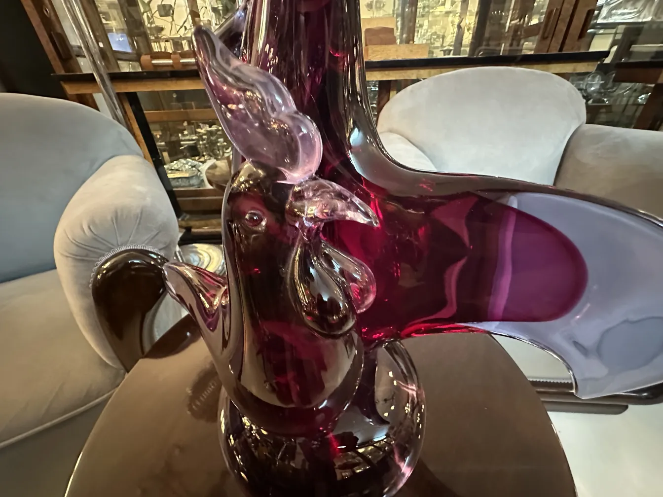 Antique Murano sculpture in purple and translucent tones, set in an elegant environment.