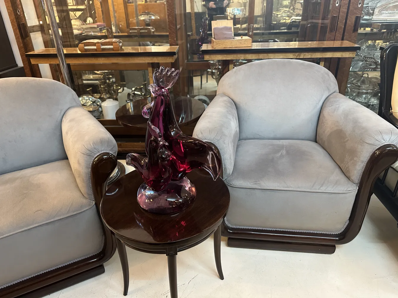 escultura de murano antigua con detalles en tonos púrpuras, situada sobre mesa circular