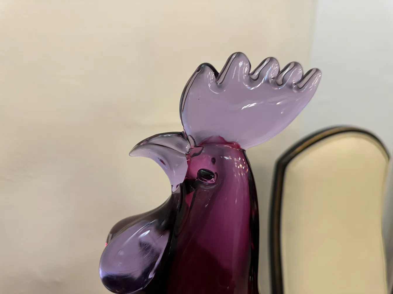 Sculpture ancienne de Murano en forme de coq coloré sur fond clair.