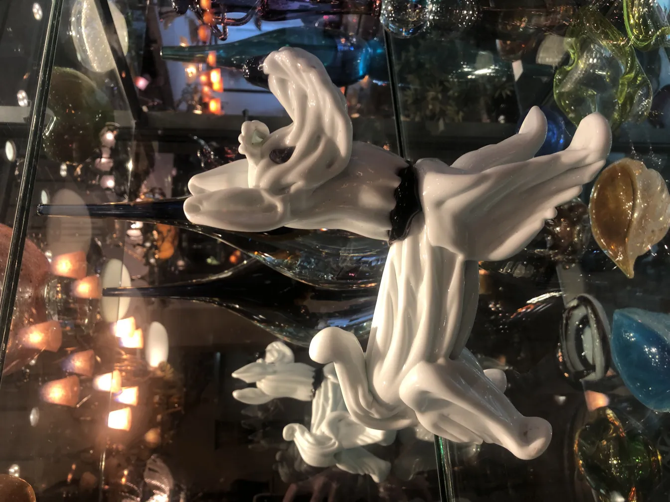 Escultura de Murano antigua en un entorno decorativo diverso, con luces cálidas