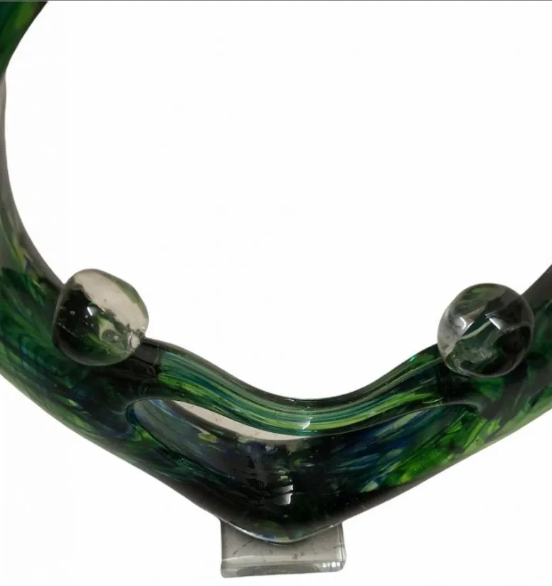 The piece features an elegant Murano sculpture with green and flowing shapes.