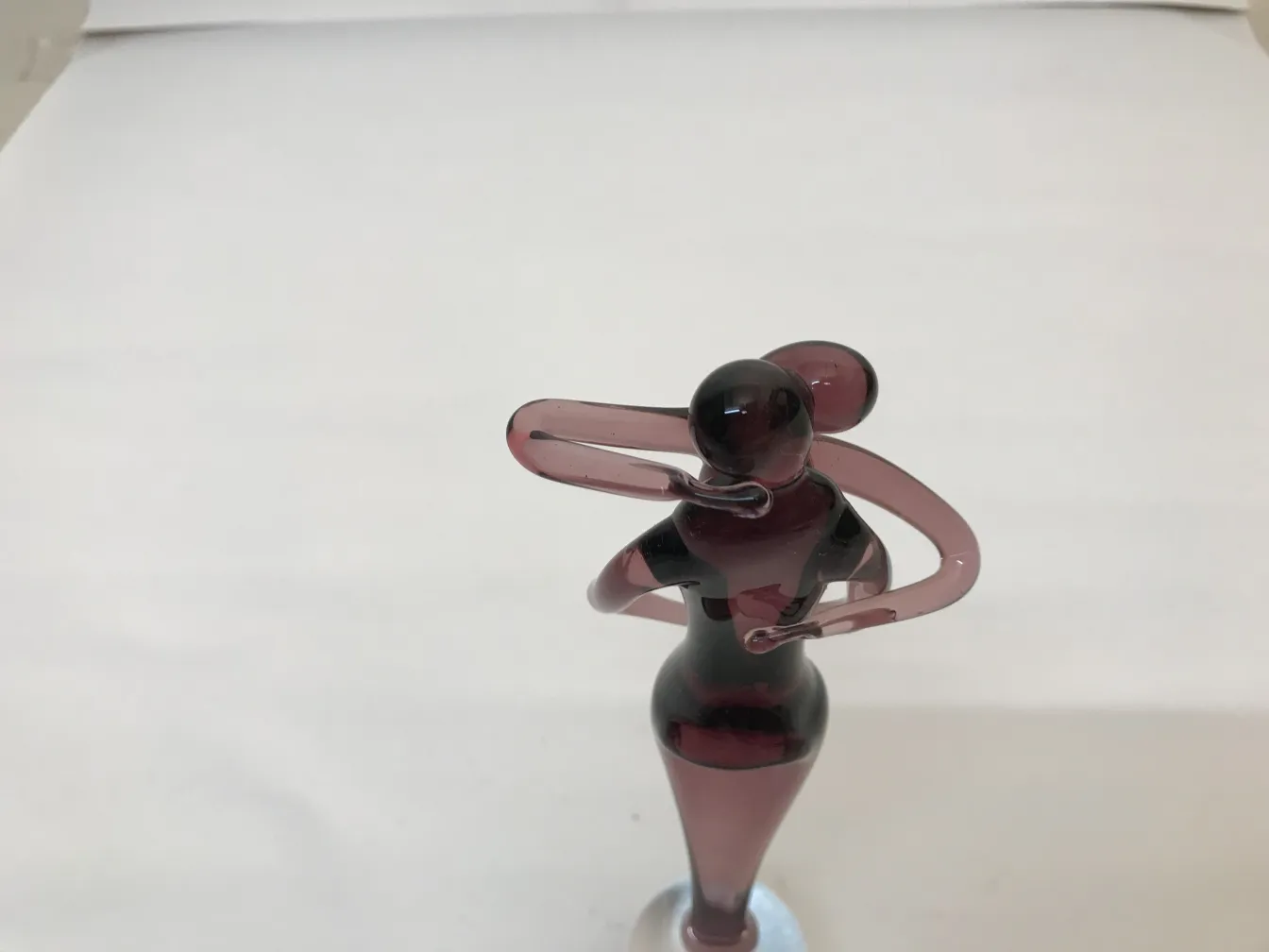 Escultura antigua de Murano con figura estilizada en tonos púrpuras