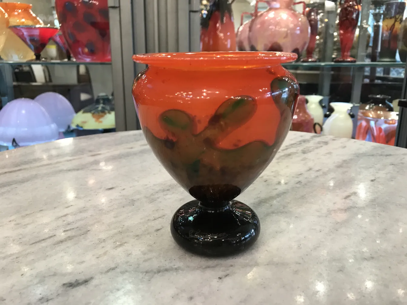 Vetro firmato Schneider colorato con base scura, decorativo su sfondi variegati.