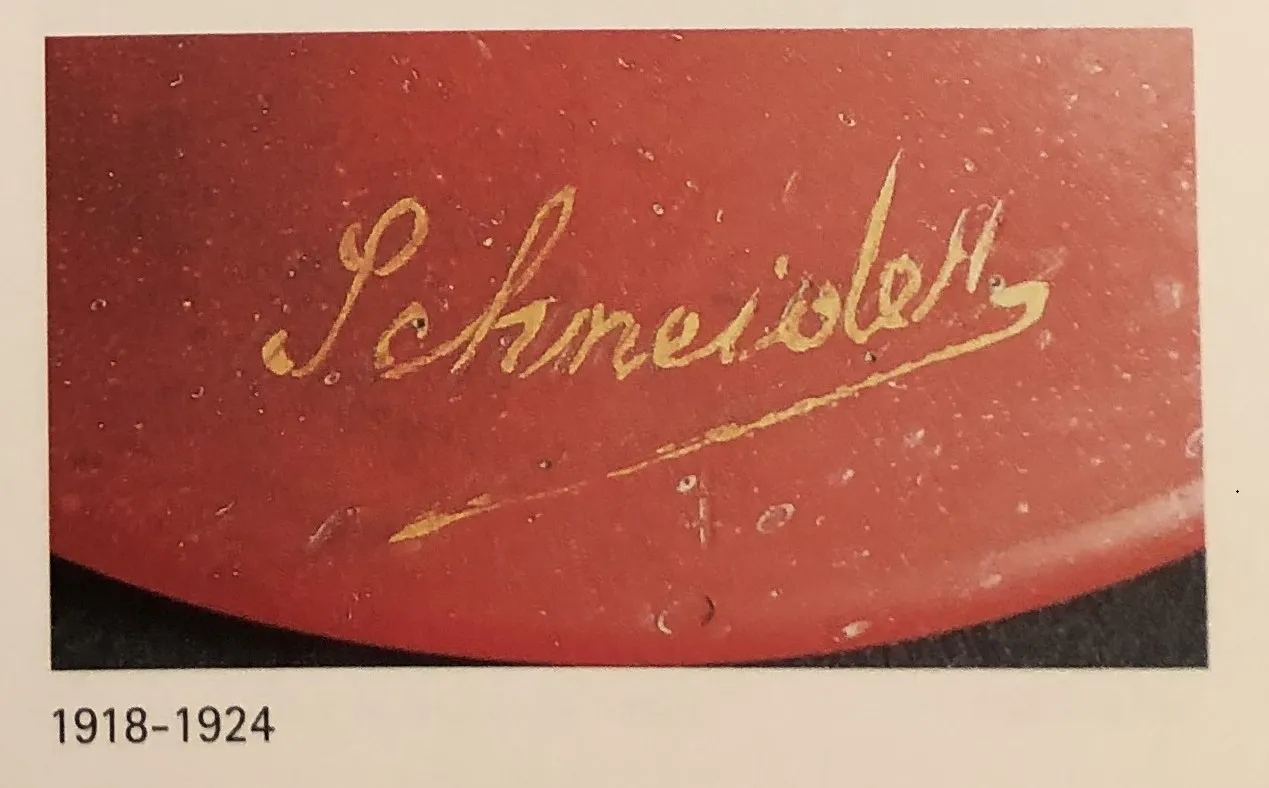 vidrio antiguo con firma de Schneider, fondo oscuro