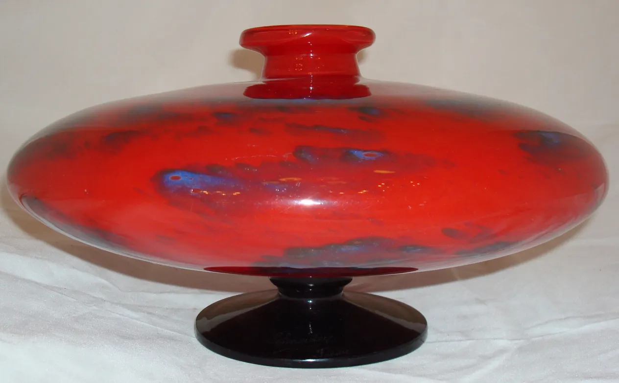 verre ancien signé par Schneider, rouge vif avec une base noire, design élégant.
