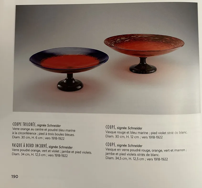 श्नाइडर द्वारा हस्ताक्षरित कांच का विवरण, जीवंत रंगों के साथ, एक प्राचीन वातावरण में।