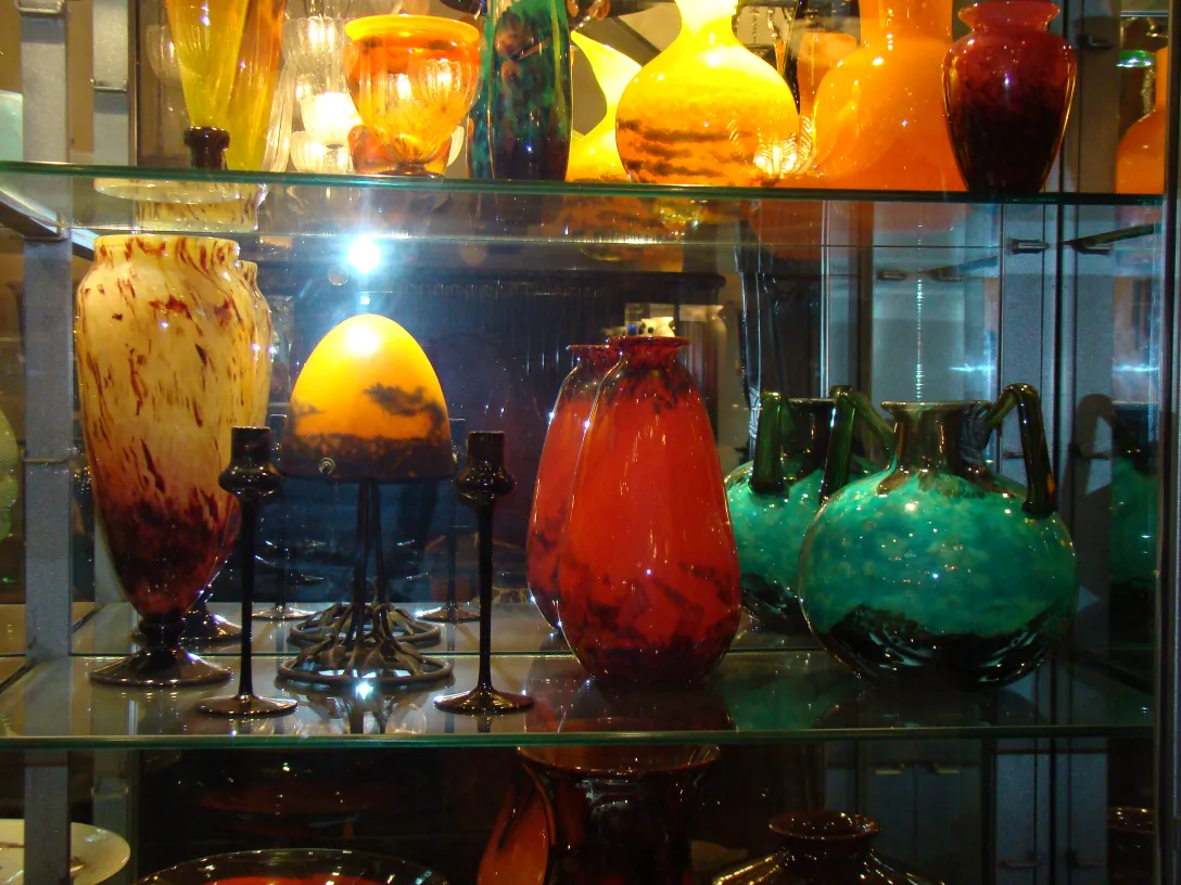 Verre ancien signé Schneider sur étagère avec d'autres objets décoratifs.