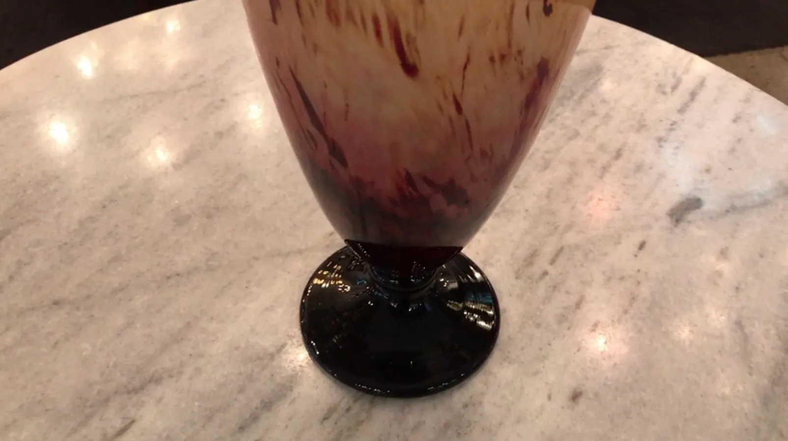 Vidro antigo assinado por Schneider com tons suaves em um ambiente sofisticado.