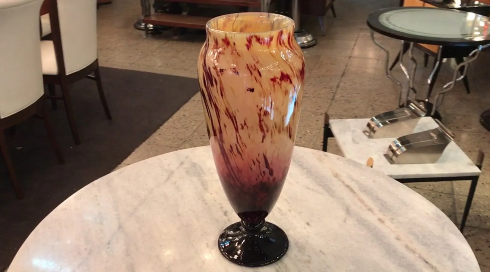 vase antigo assinado na base, tons quentes e design ondulado, em ambiente elegante