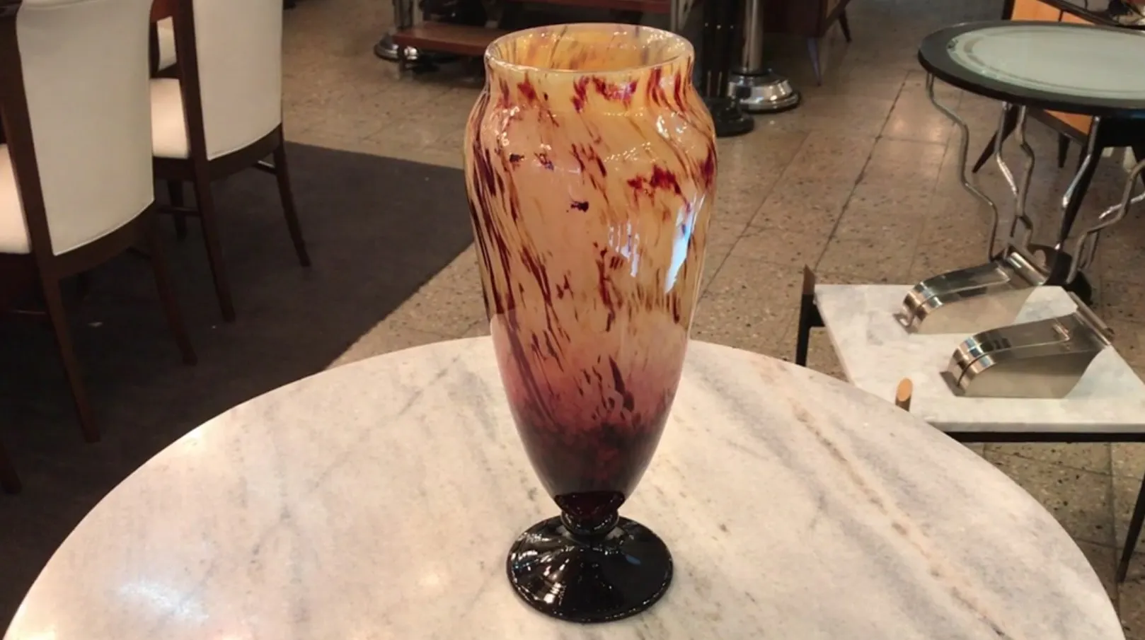 Vaso decorativo de vidro assinado Schneider, apresentando tons terrosos e avermelhados em um ambiente elegante.