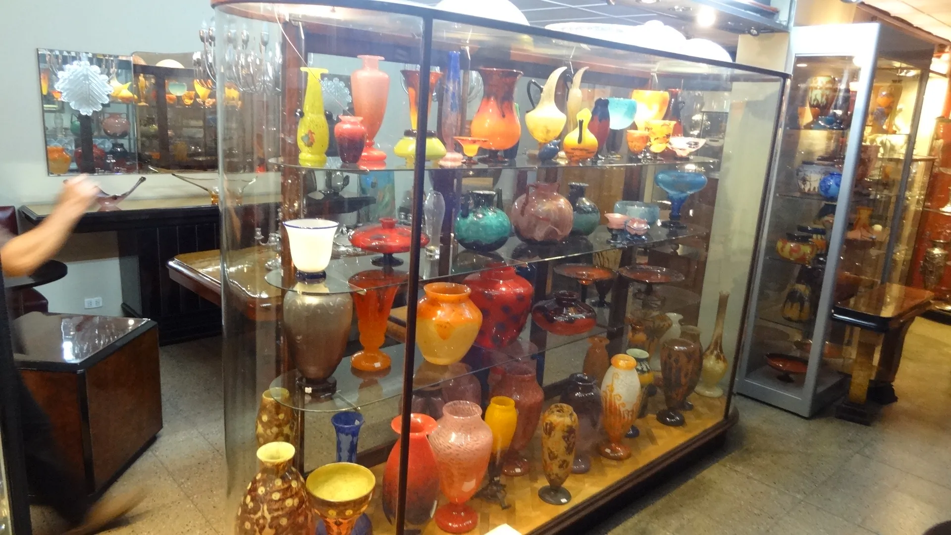 Showcase with antique signed glass Schneider and colorful decorations.