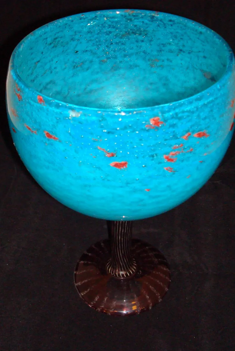 زجاج موقّع شنيدر باللون الأزرق مع تفاصيل حمراء، بيئة مظلمة.