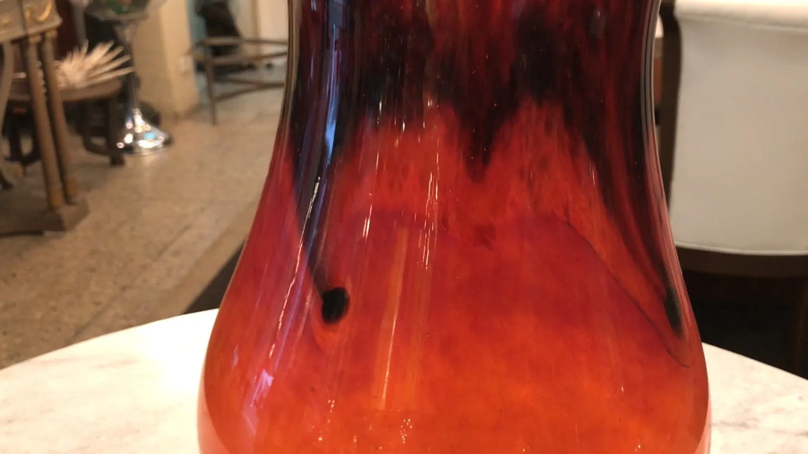 Vidro antigo assinado com detalhes em vermelho e preto.