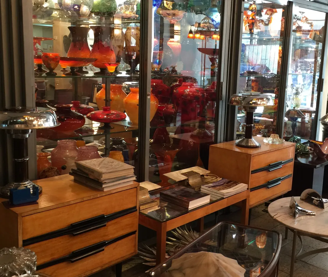 Verre signé Schneider présenté parmi des antiquités avec du verre coloré à l'arrière.