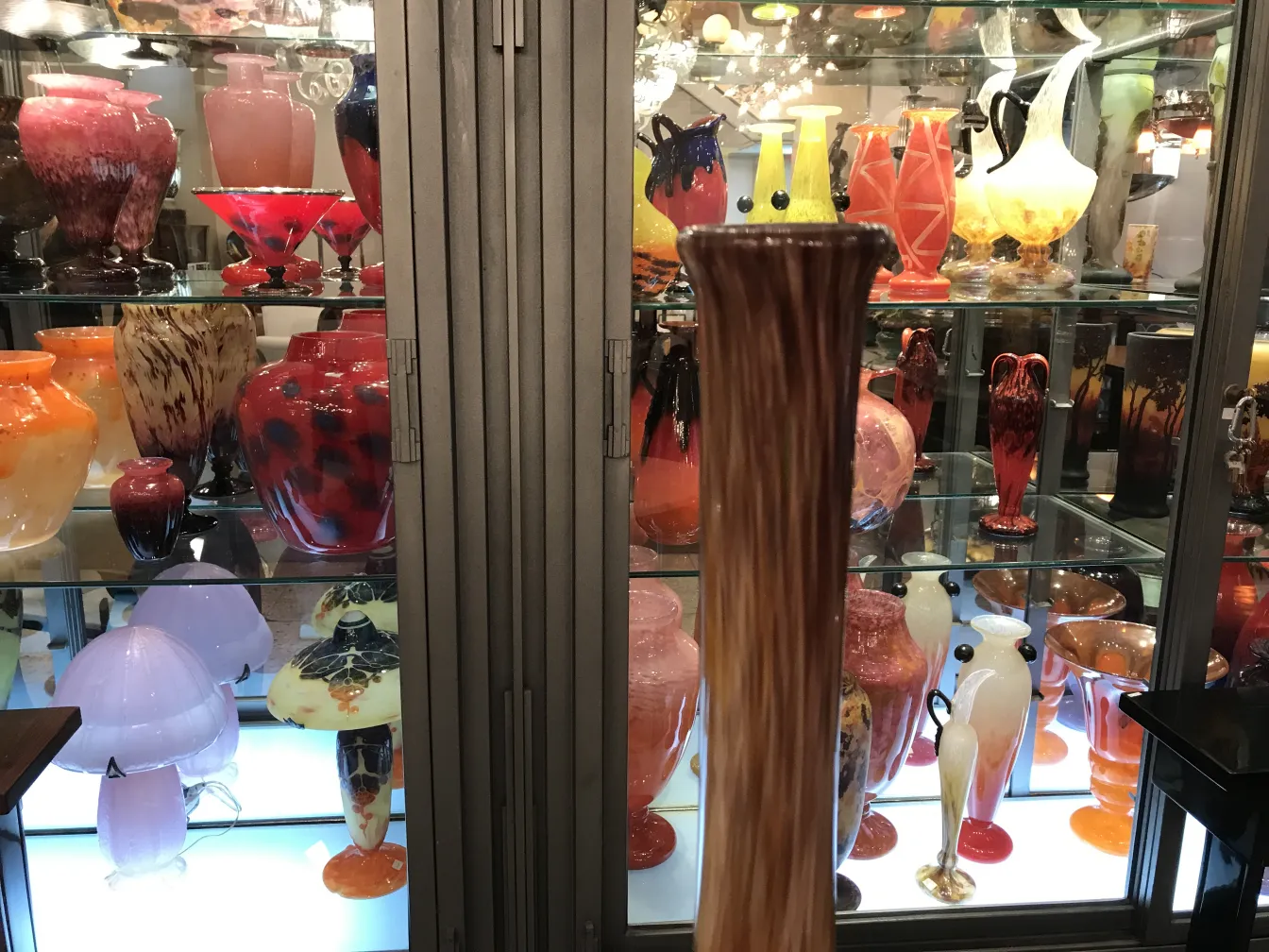 antikes Glas mit Unterschrift, präsentiert zwischen anderen Farben und Formen