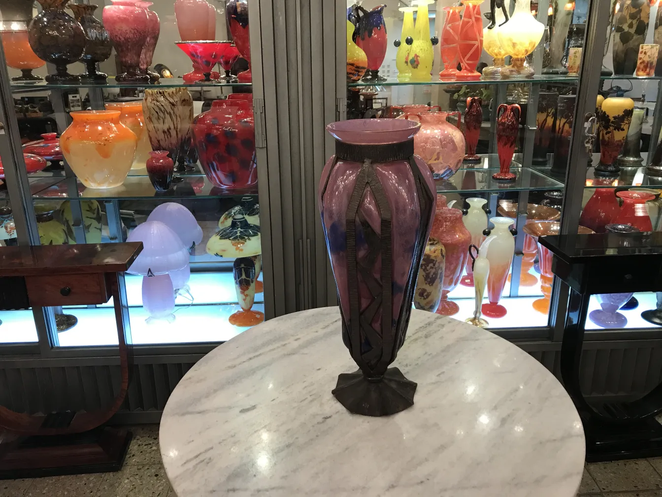 Ancienne pièce de verre signée avec un design décoratif, fond coloré.