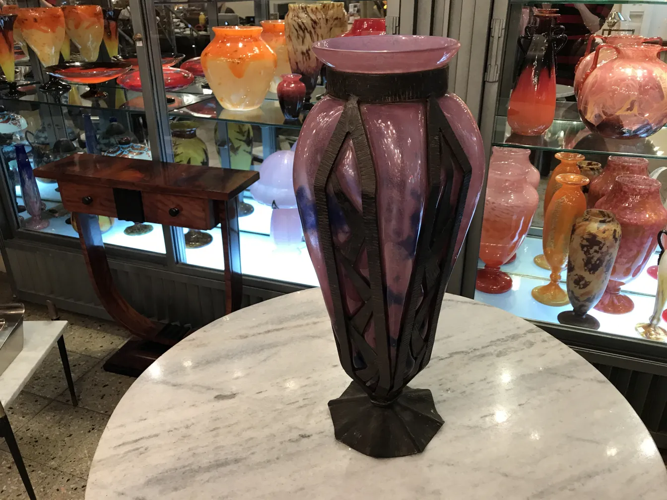 vase ancien en verre signé exposé dans une boutique d'antiquités, avec une base structurée