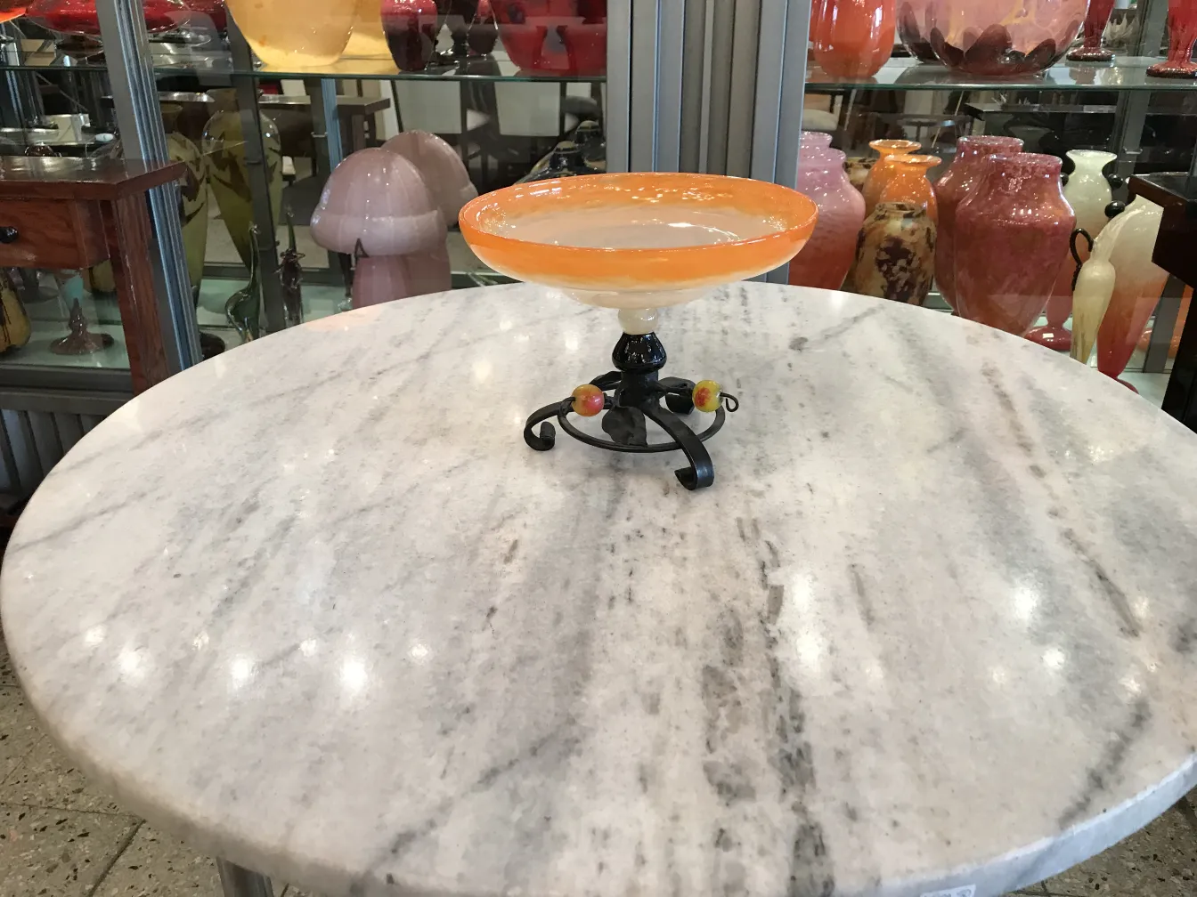 Glass with black base and colorful accents in an antique setting.