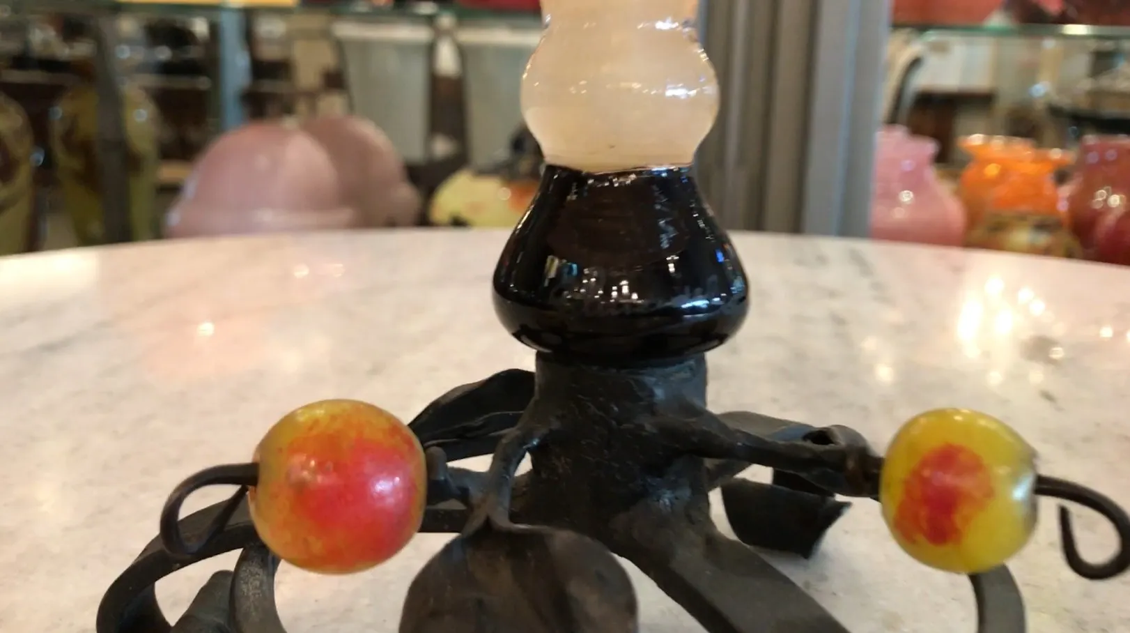 Vidro assinado de estilo francês com detalhes escuros e elementos decorativos em um ambiente antigo.