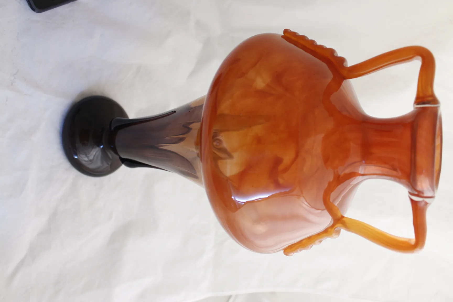 シュナイダーのサイン入りグラスは暖かい色調とシンプルな背景でエレガントな形を示しています。