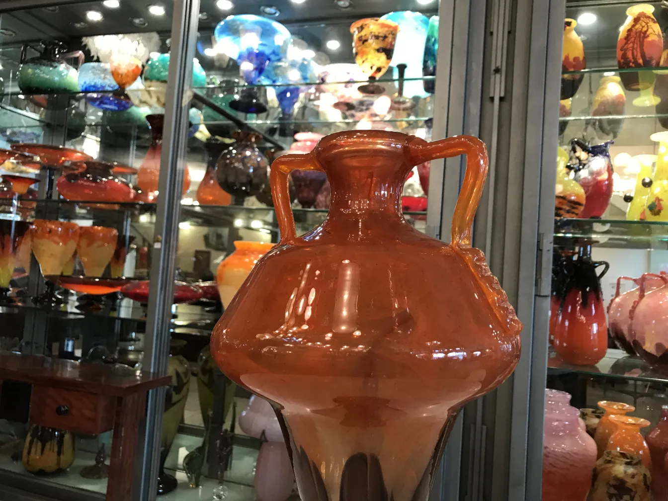 antikes signiertes glas schneider in orange vor verschiedenen anderen glasobjekten