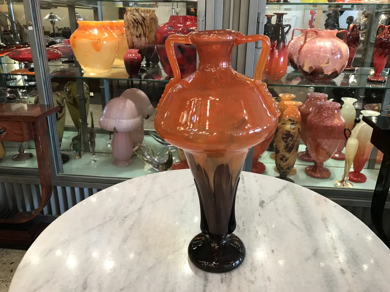 jarrón de vidrio firmado en tonos naranja y marrón con fondo decorativo