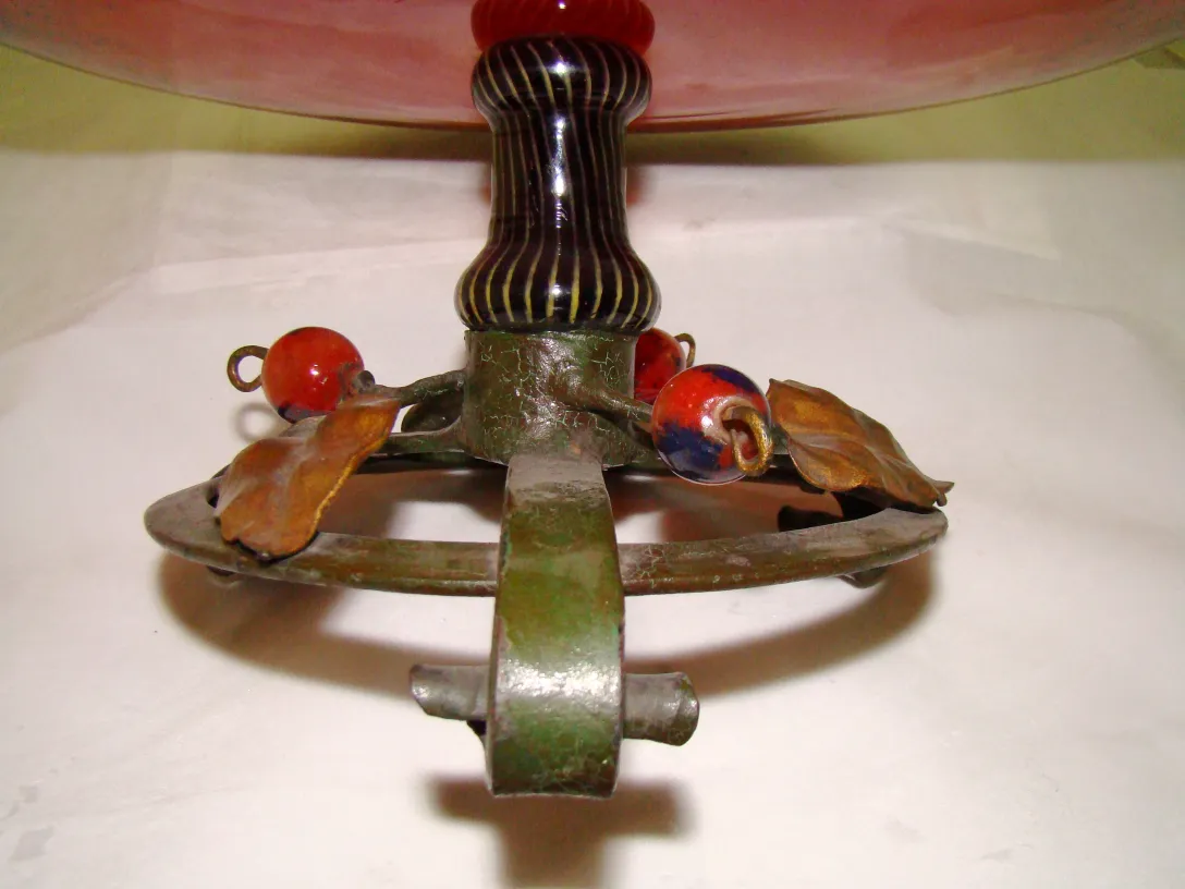 Base de vidro assinado Schneider em um ambiente antigo com detalhes verdes e vermelhos.