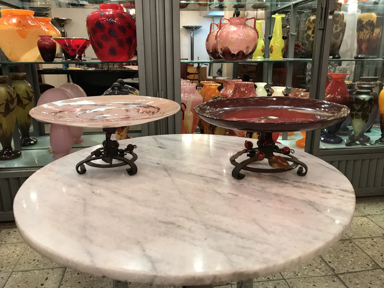 Prato de vidro antigo assinado por Schneider sobre pedestal decorativo.