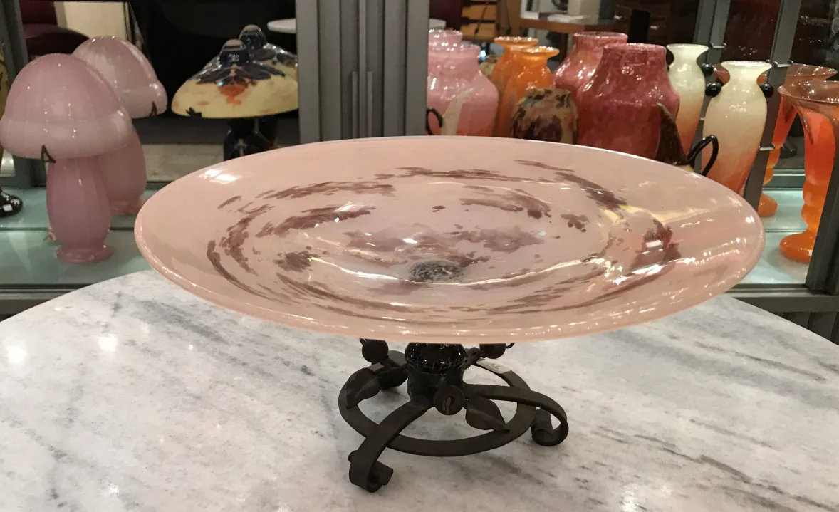 Assiette décorative en verre signé Schneider avec base en métal, couleurs douces.