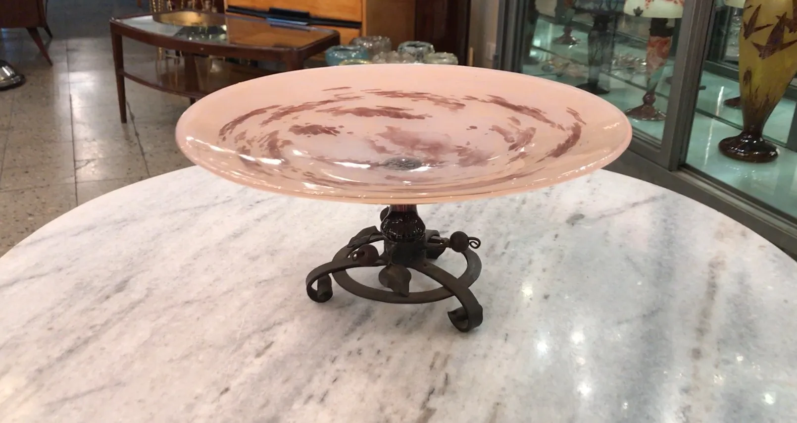 Prato de vidro antigo com assinatura de Schneider, cor suave, em base decorativa.