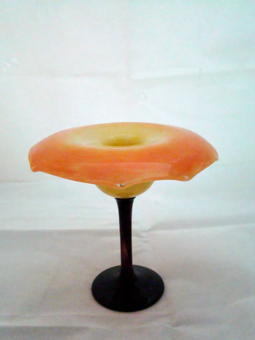 Signed glass Schneider with colorful shape on a pedestal.